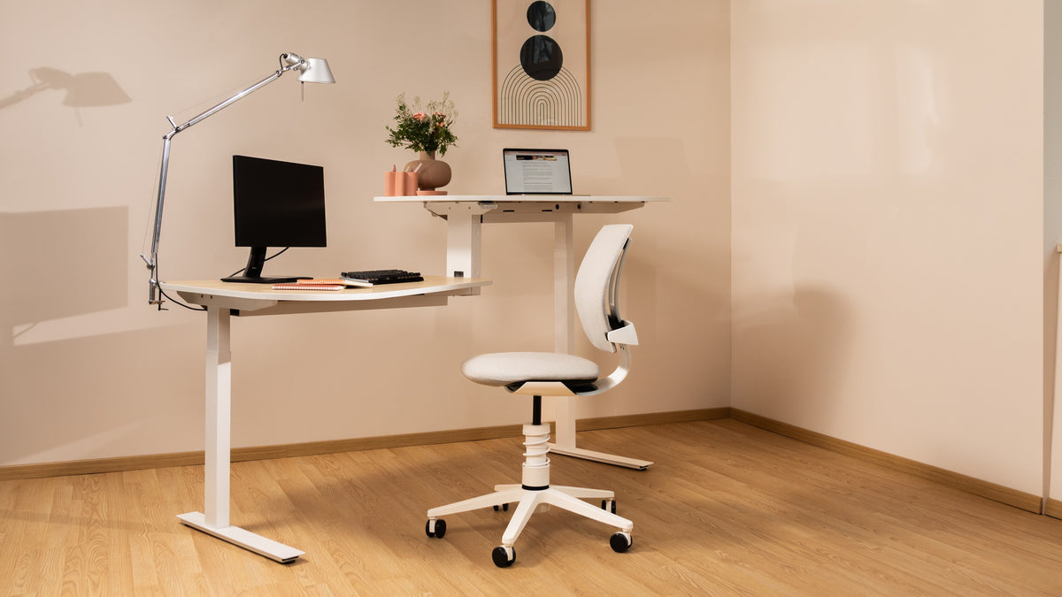 White 3Dee active chair at a height-adjustable desk in a bright home office with a monitor