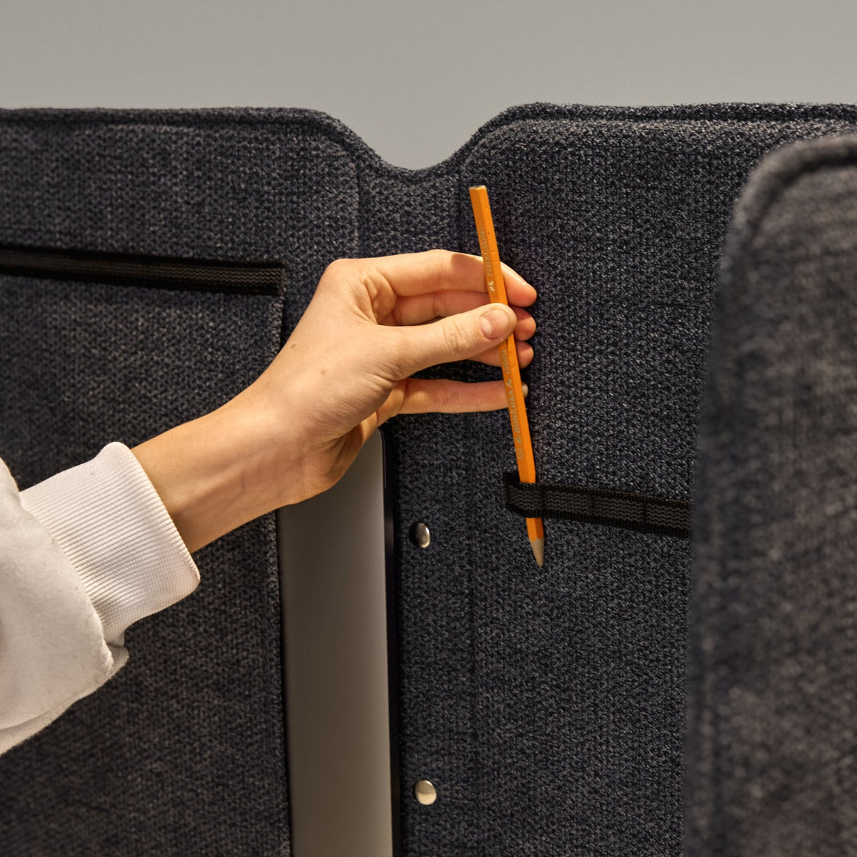 Hand placing a pen into the pocket on the Easy School desk screen
