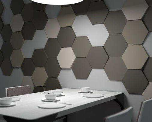 Wall of grey hexagonal Focus acoustic panels behind a meeting table