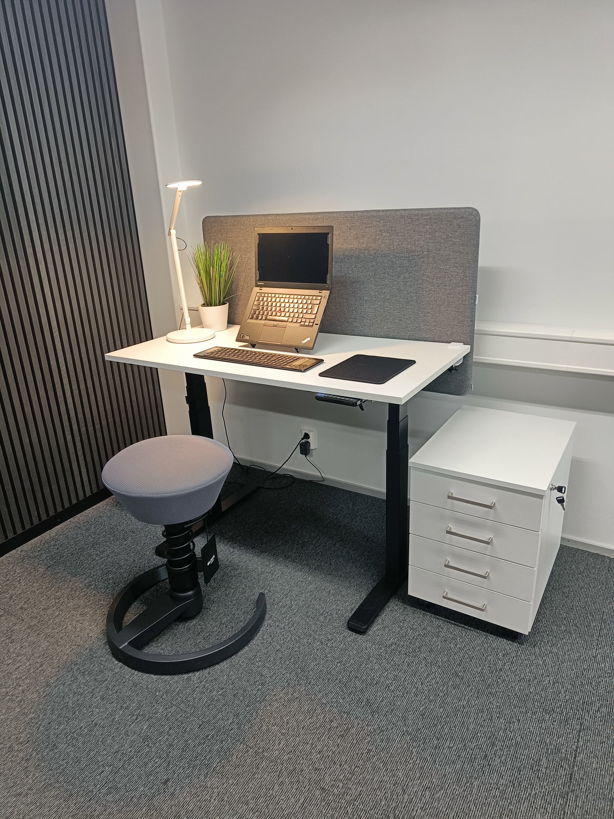 Office workstation with a white four-drawer pedestal beside the desk
