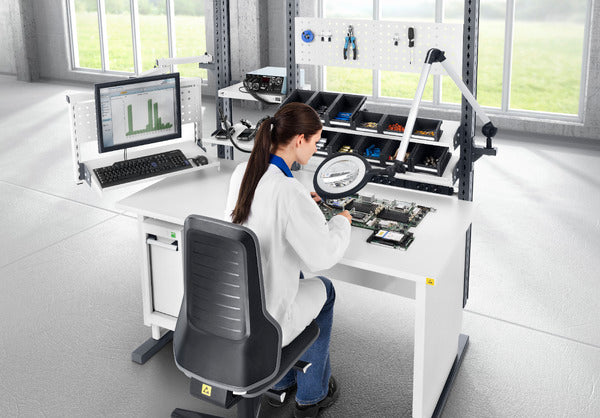 Laboratory worker seated on a Neon 2 ESD work chair at a workstation