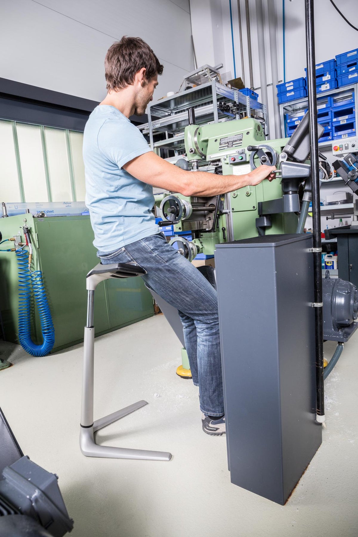 Technician leaning on an ESD protected FIN chair while working on industrial equipment