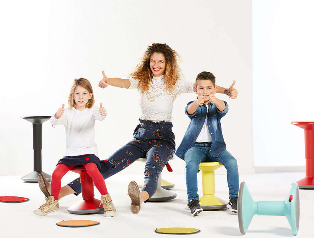 Three children posing with UPis1 Junior stools in bright colours