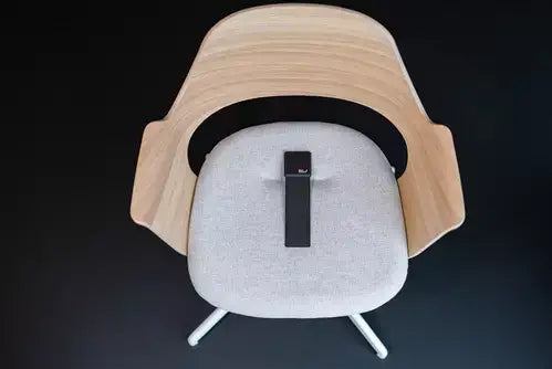 Seat Guard microbreaks device on a modern wooden chair cushion for enhanced sitting comfort