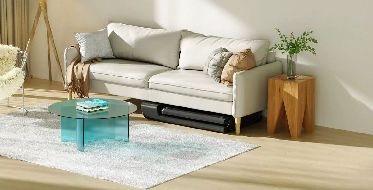 Compact WalkingPad Pro treadmill stored neatly under modern sofa in stylish living room setting.