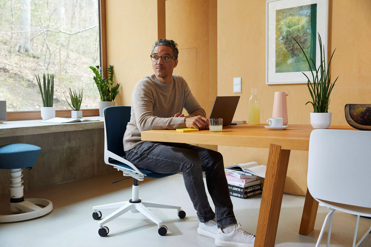 Man working at a desk on a Numo Task active chair in a bright office