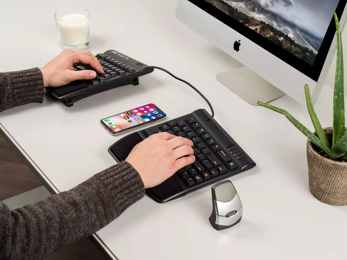 Hands typing on a Freestyle 2 keyboard raised on VIP3 tenting brackets