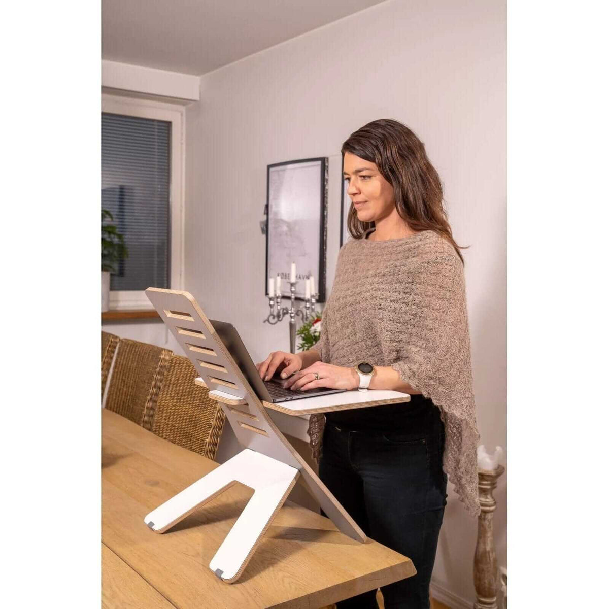 Woman using a laptop on a GetUpDesk Light stand at a table