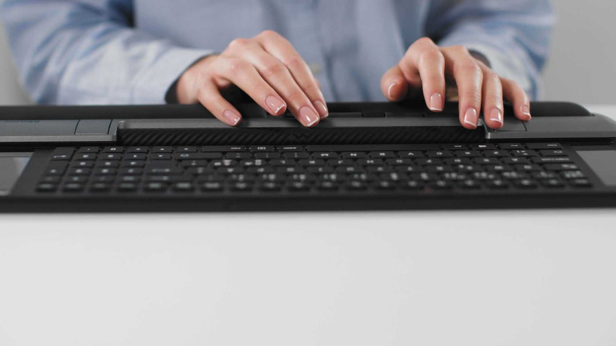 Person using a Delta Extended black Mousetrapper for smooth navigation and custom shortcuts at a desktop workspace.