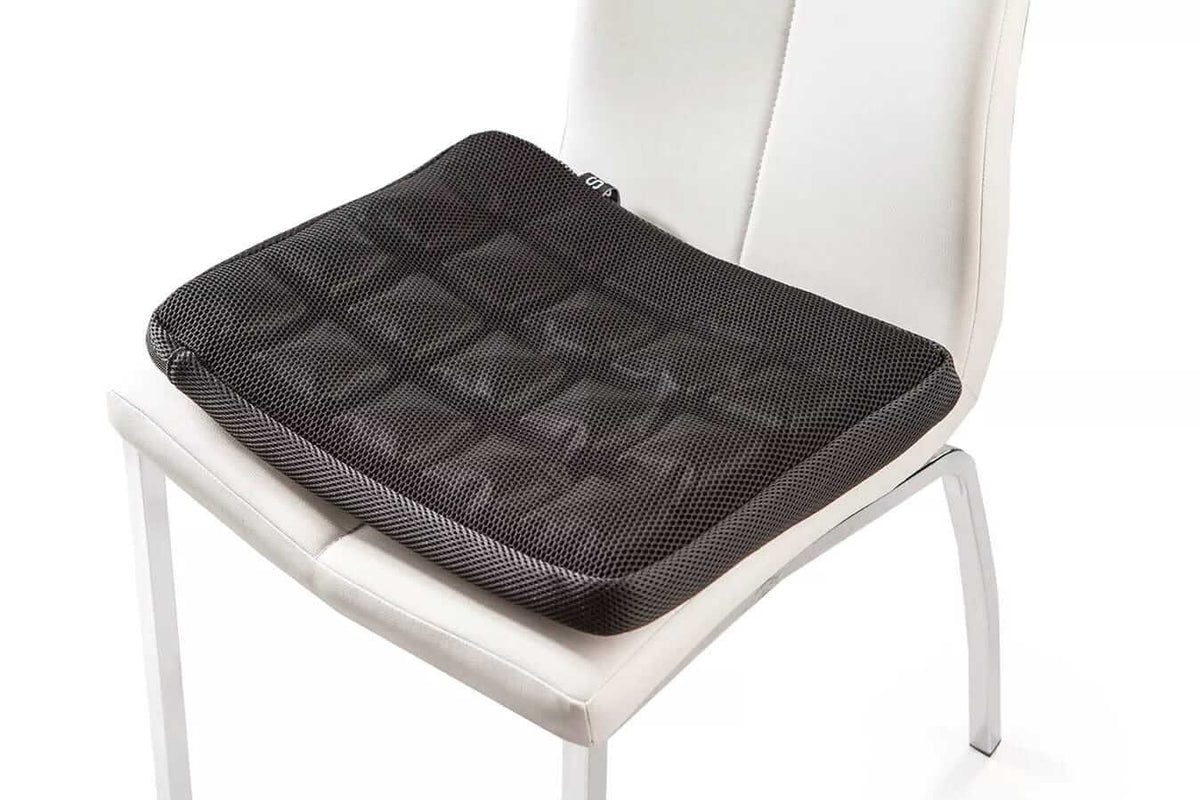 SitCell air cushion seat placed on a white chair, viewed at an angle