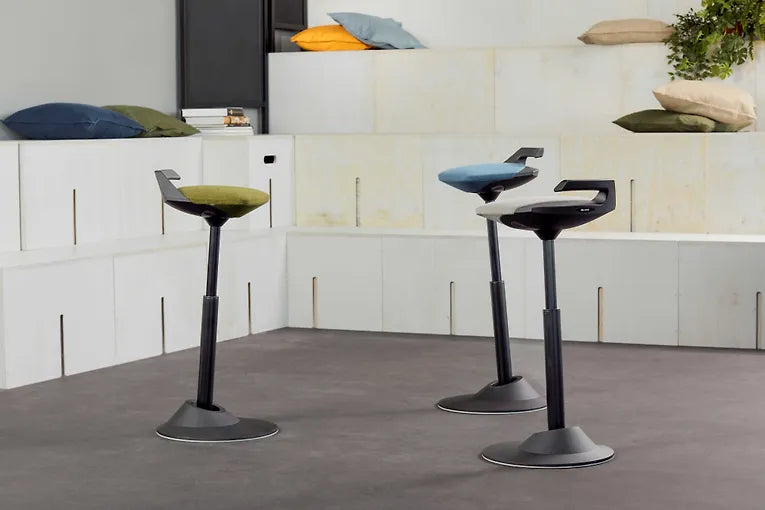 Two Muvman active standing stools with blue seats in an office