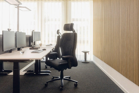Open-plan office with XXLis5 chairs at desks along a wooden wall
