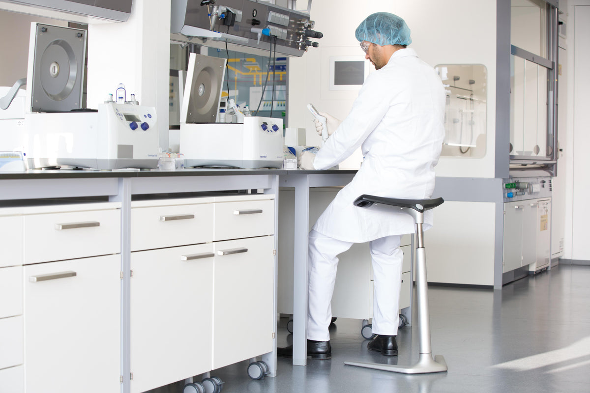 Laboratory technicians working at benches with ESD protected FIN leaning chairs