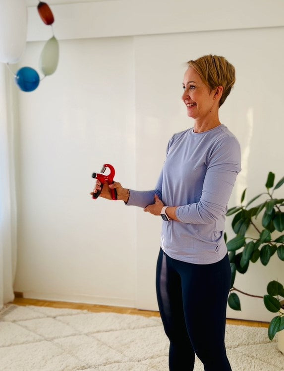 Woman exercising with red resistance band handles