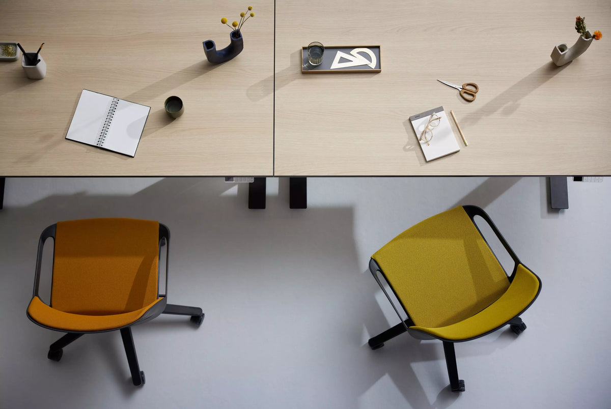 Office desks with orange and yellow Numo Task active chairs