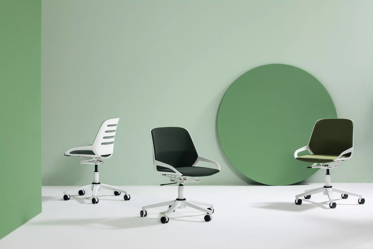Numo Task active chairs in white and black against a green studio backdrop