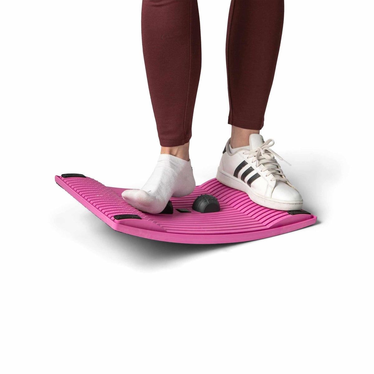 Person using pink Gymba activation board for improved movement and health benefits at work, enhancing metabolism and alertness.