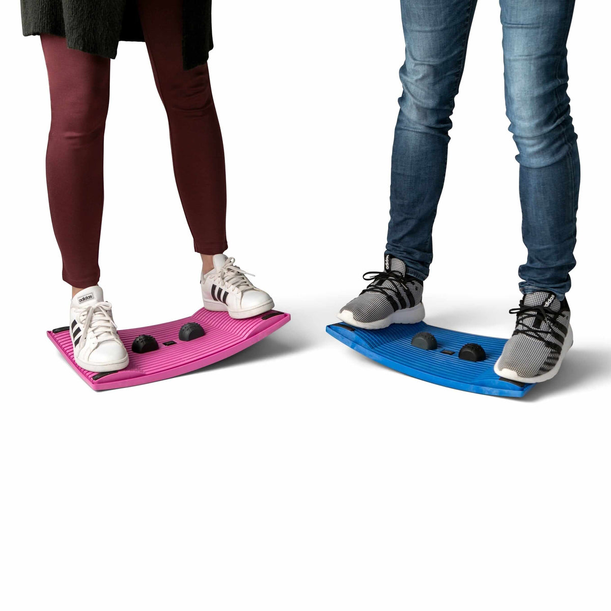 Two people balancing on pink and blue Gymba activation boards, promoting movement and improved concentration at work.